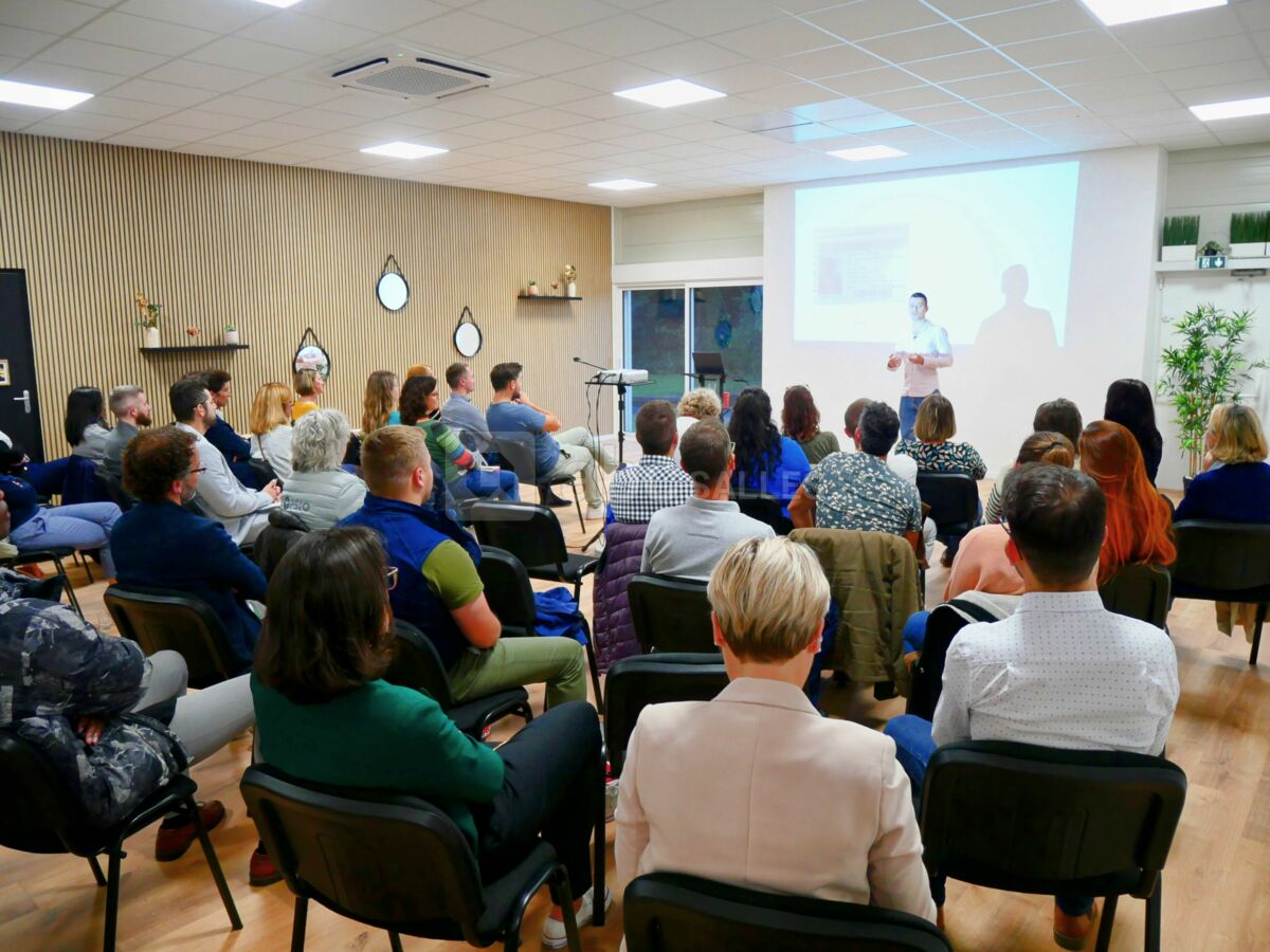 Salle de conférence avec le public de dos pendant un événement thérapeutique